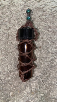 a brown bottle with a blue bead on it